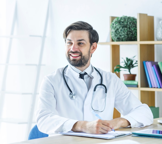 Cheerful doctor making notes and looking away