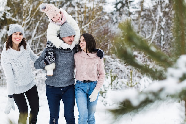 Cheerful family walking in winter forest