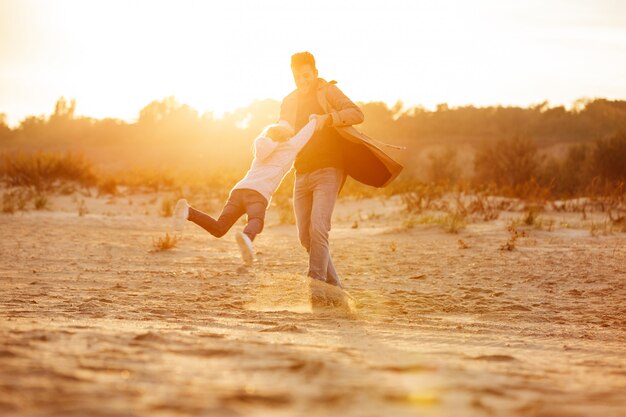 Cheerful father playing with his little daughter