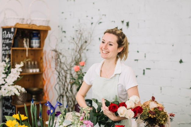 Cheerful florist holding rose bouquet