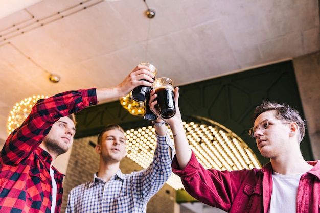 Cheerful friends clinking glasses in bar