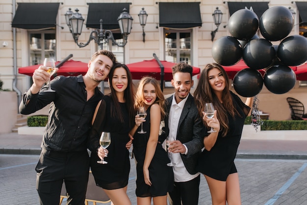 Free photo cheerful friends drinking champagne at party outdoors