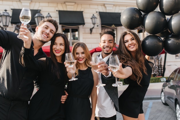 Cheerful friends drinking champagne at party outdoors