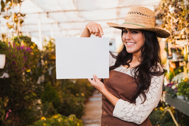 Cheerful gardener pointing at paper sheet