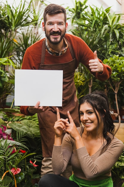 Free Photo cheerful gardeners with sheet of paper