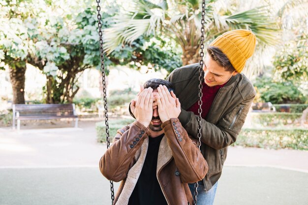 Cheerful gay couple having fun in park