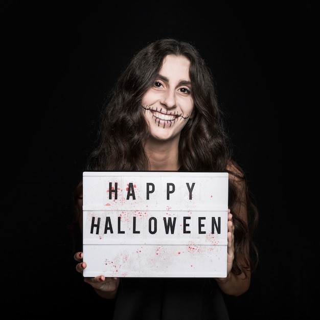 Cheerful girl holding signboard