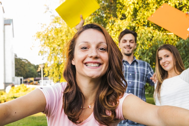 Cheerful girl posing with students