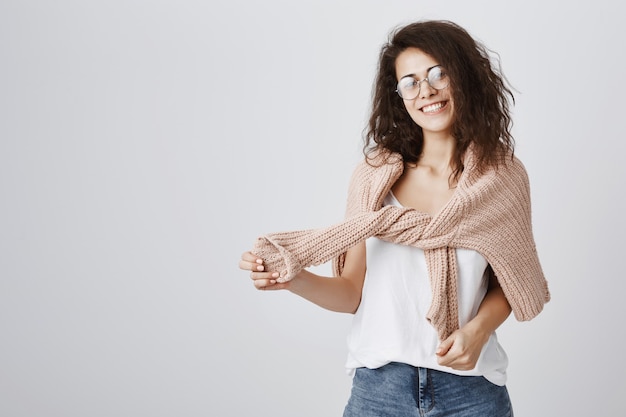 Cheerful girl smiling, wrap sweater around shoulders