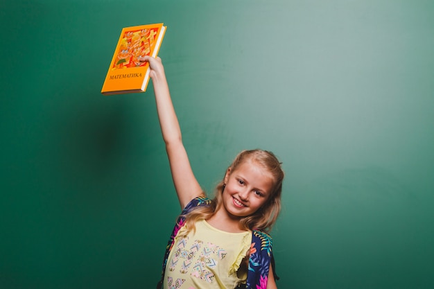 Free photo cheerful girl with book in class