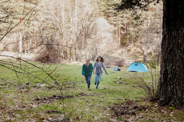 Free photo cheerful girls running in the field