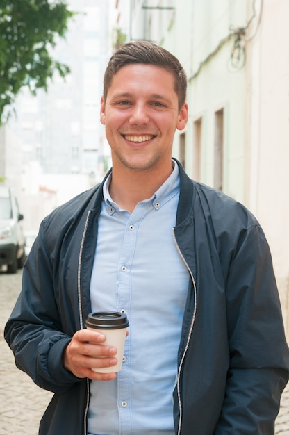 Cheerful guy enjoying outdoor coffee break