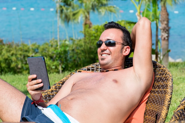 Cheerful guy with his mobile resting outdoors