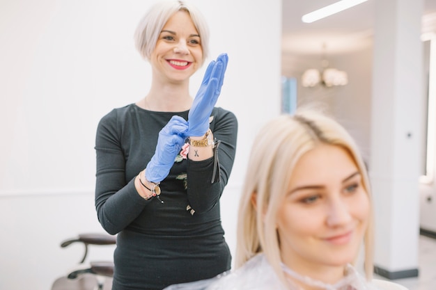 Free photo cheerful hairdresser preparing for coloring procedure