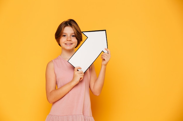 Free photo cheerful handsome girl holding arrow left and looking camera