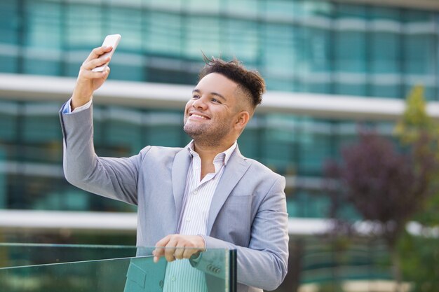 Cheerful handsome intern photographing himself