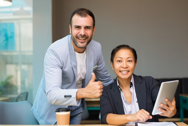 Cheerful Hispanic man showing thumb-up while giving estimation