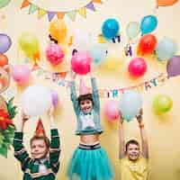 Free photo cheerful kids holding balloons