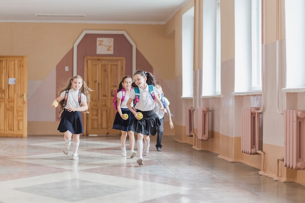 Free photo cheerful kids running in school corridor