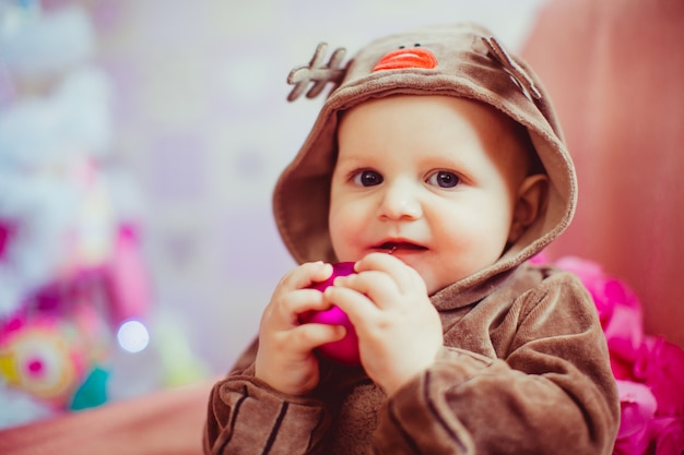 Free photo cheerful little baby boy playing near the christmas tree