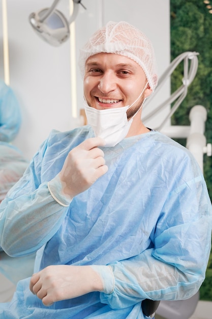 Cheerful male dentist sitting in dental office