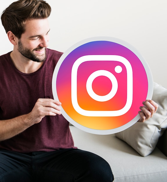 Free Photo cheerful man holding an instagram icon