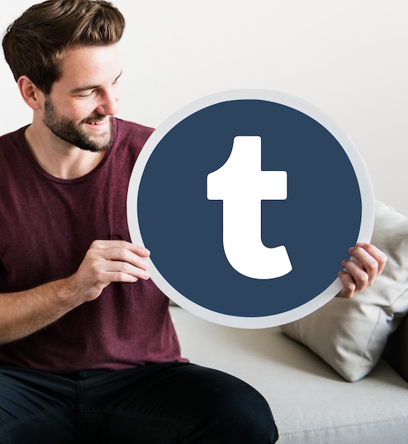 Free photo cheerful man holding a tumblr icon