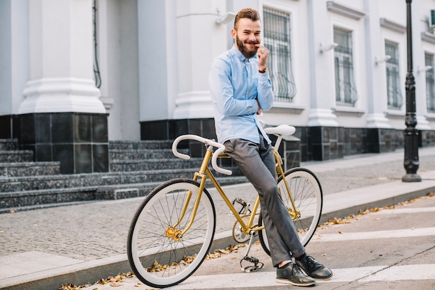 Free photo cheerful man leaning on bicycle