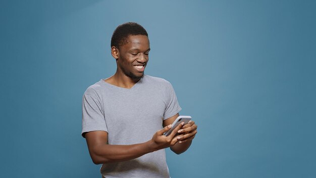 Cheerful man reading good news and achievement on smartphone, celebrating successful win and accomplishment. Adult feeling happy and pleased about success and victory, browsing phone internet.