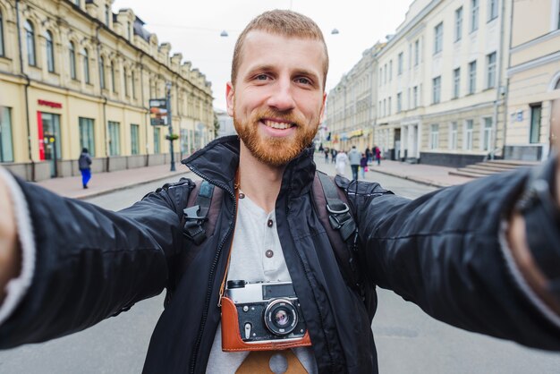 Cheerful man selfies in city