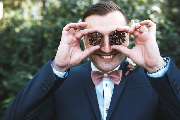 Free Photo cheerful man in suit posing with cones