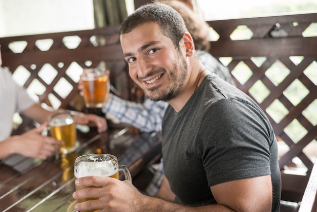 Cheerful man with beer looking at camera