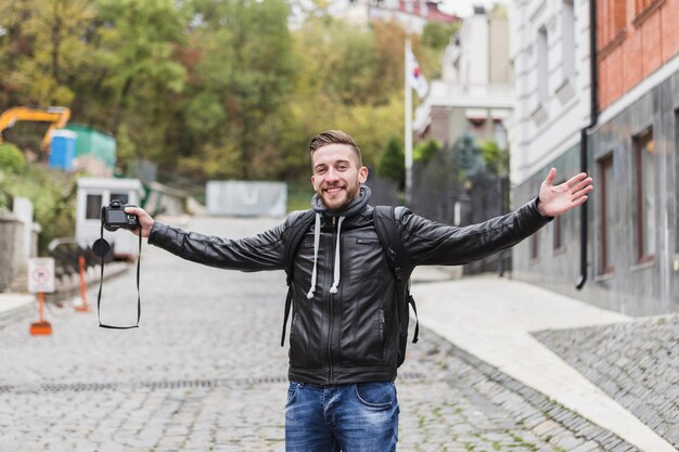 Free Photo cheerful man with camera on street