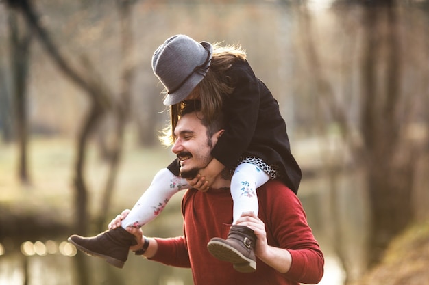 Free photo cheerful man with girl on shoulders