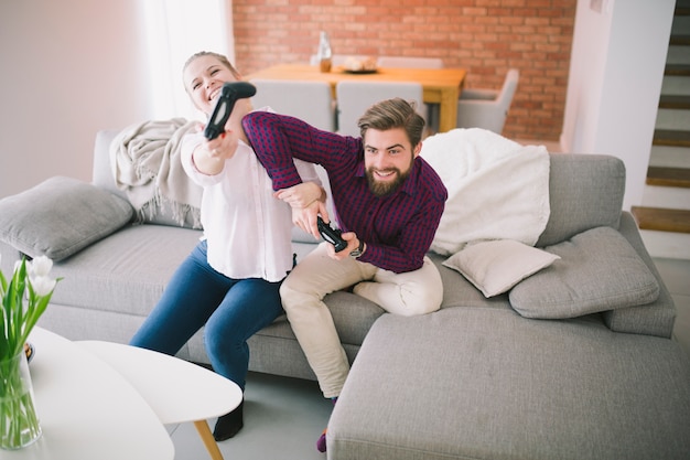 Cheerful man and woman playing console