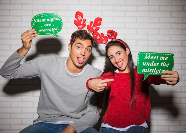 Cheerful man and woman with Christmas hats 