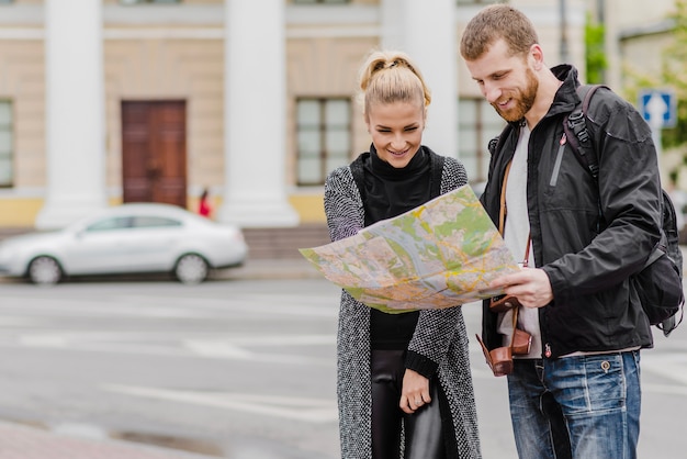 Free photo cheerful man and woman with map