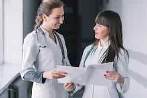 Free photo cheerful medic women with papers in clinic