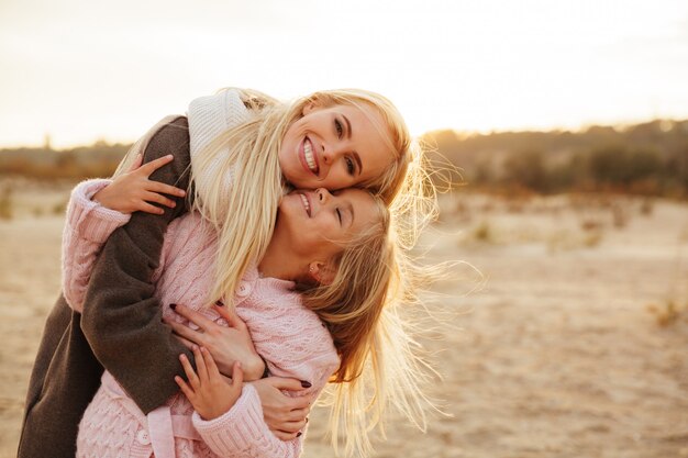 Cheerful mother playing with her little daughter