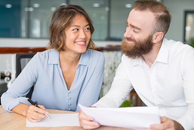 Cheerful office employees flirting and joking