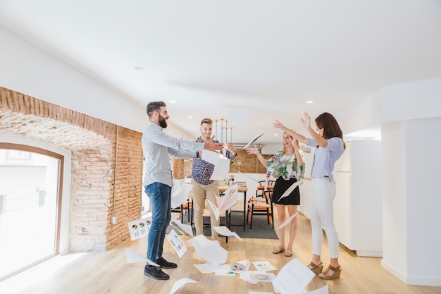 Cheerful people in office throwing papers