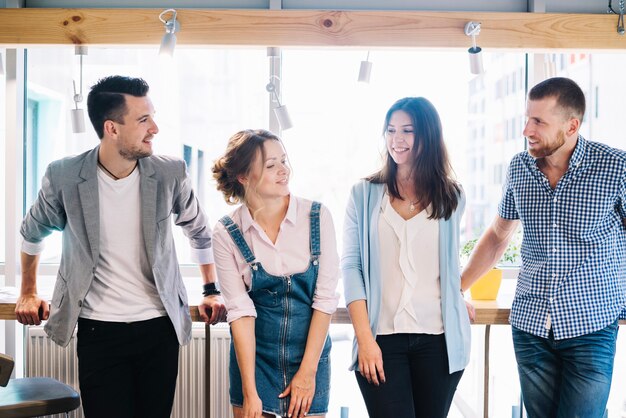 Cheerful people standing near window in office