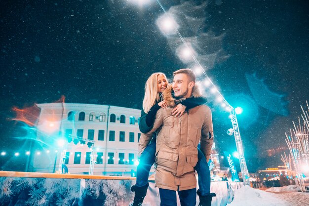 Cheerful and playful couple in warm winter outfits are fooling around