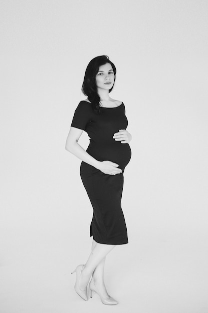 Free Photo cheerful pregnant caucasian womaan waiting her baby and touching her tummy, black and white picture isolated on white background