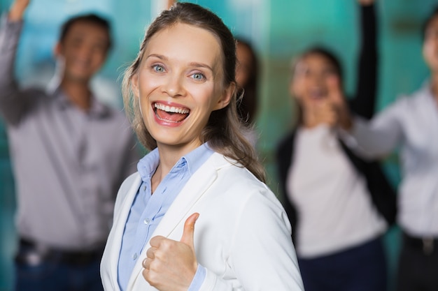 Free photo cheerful pretty business woman showing thumb up