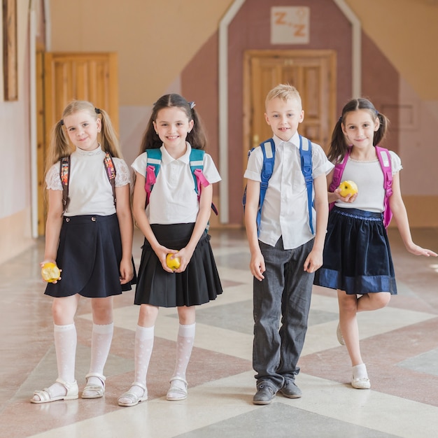 Free photo cheerful pupils with apples