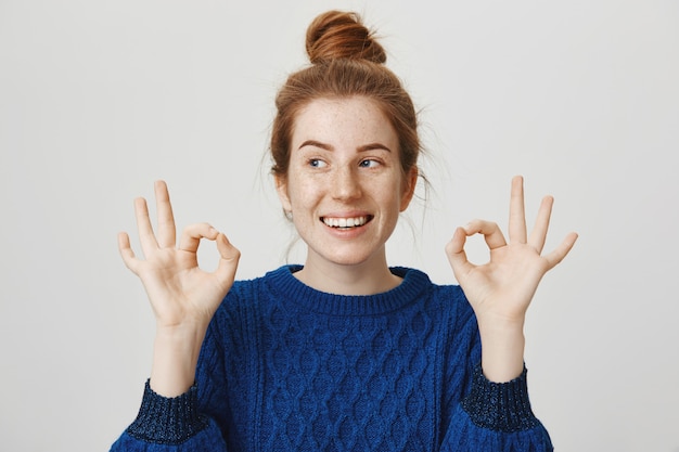 Free Photo cheerful redhead girl smiling, showing okay in approval, assure everything good