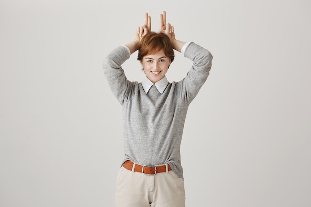 Free Photo cheerful redhead girl with short haircut posing against the white wall