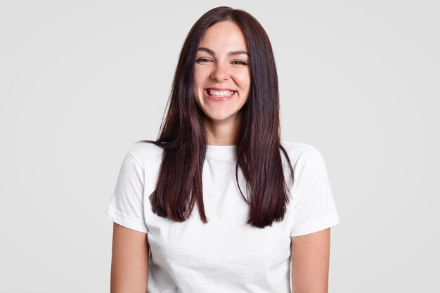 Cheerful satisfied brunette lady has toothy smile, being in good mood expresses positive emotions