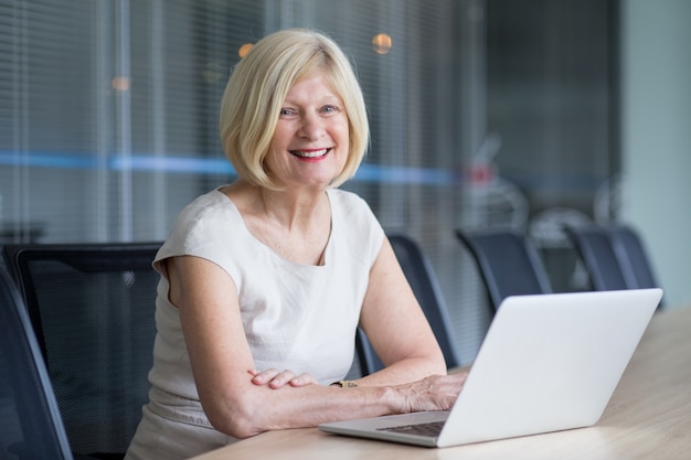 Cheerful senior businesswoman working in office